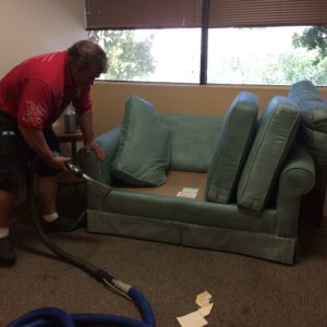 man cleaning a sofa