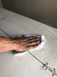 a hand wiping a suface covered with soot