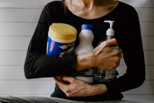 A woman holding cleaning supplies